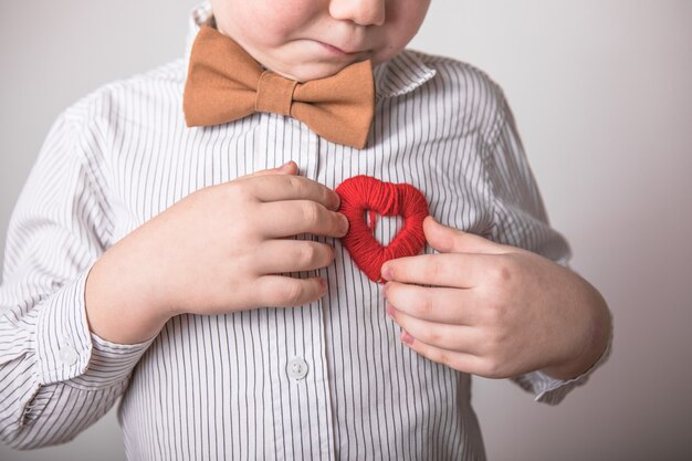 Enfant tenant un petit coeur rouge