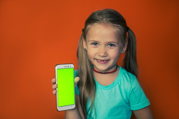 Enfant tenant verticalement un smartphone avec écran vert