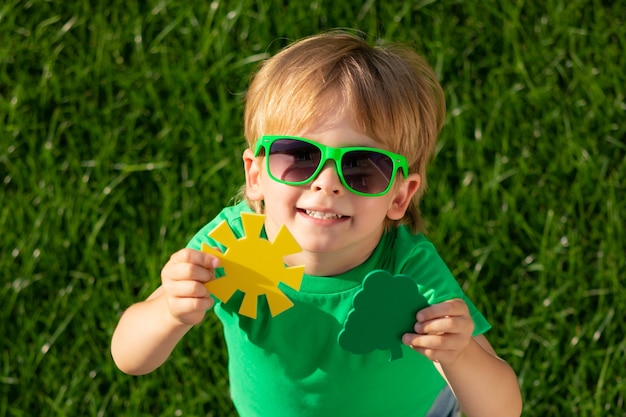 Enfant, tenue, arbre vert, et, soleil, dans, mains