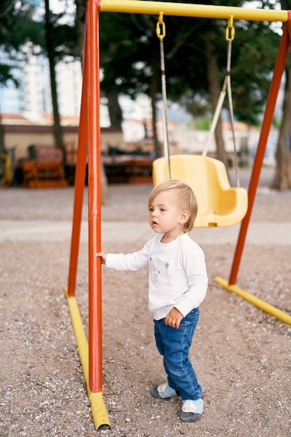 L'enfant tient la balançoire avec sa main