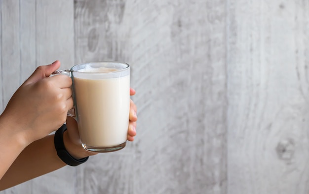 L'enfant tient dans ses mains une coupe en verre avec du lait cuit au four fermenté.