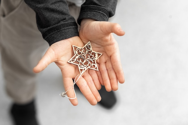 L'enfant tient dans ses mains un flocon de neige décoratif une étoile Décoration pour l'arbre de Noël