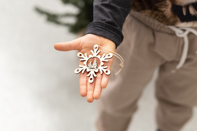 L'enfant tient dans ses mains un flocon de neige décoratif une étoile Décoration pour l'arbre de Noël