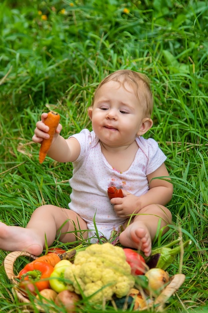 L'enfant tient des légumes dans ses mains. Mise au point sélective. Enfant.