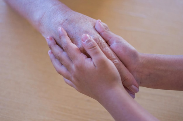 Un enfant tient les mains d'un homme et d'une femme.