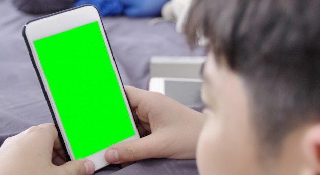 L&#39;enfant tient un téléphone dans sa main avec un écran vert.