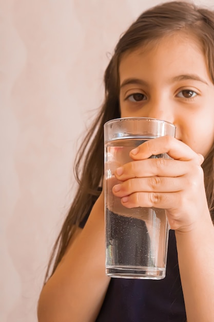 L'enfant tient un verre d'eau dans ses mains. mise au point sélective.personnes