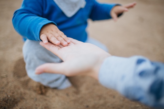 Enfant touchant une main adulte