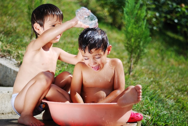 Enfant très mignon jouant avec de l&#39;eau en plein air