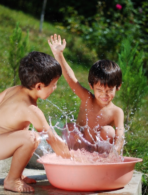 Enfant très mignon jouant avec de l&#39;eau en plein air