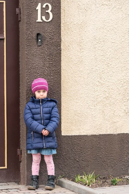 enfant triste au mur de la maison avec le numéro treize