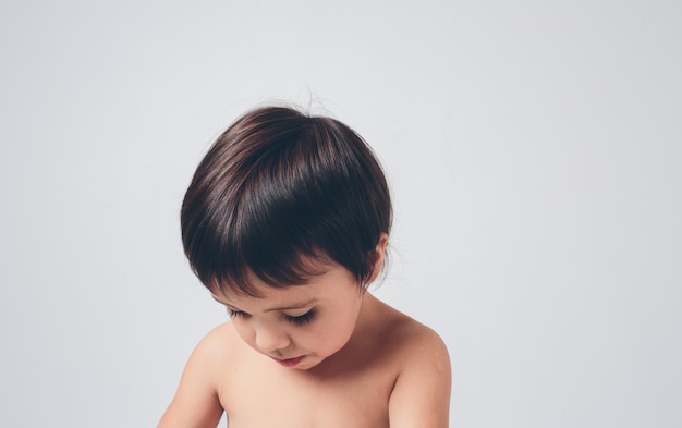 Un enfant triste et désorienté regarde un blanc. Le branchie ou le garçon a les cheveux et la peau bruns