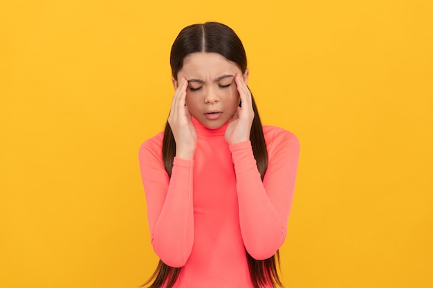 Enfant triste avec mal de tête sur fond jaune stress