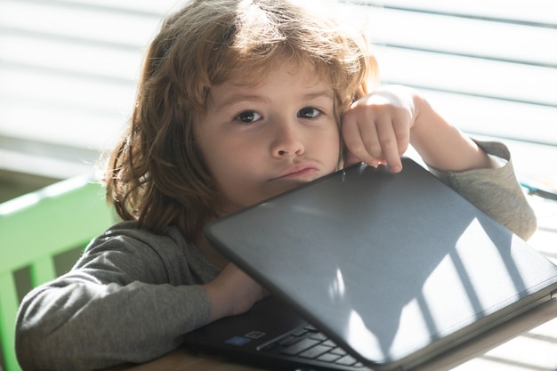 Enfant triste avec ordinateur portable. Difficile à comprendre. Retour à l'école. Élève pensant. Devoirs.