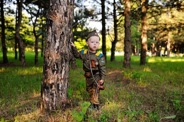 Enfant en uniforme militaire dans la nature