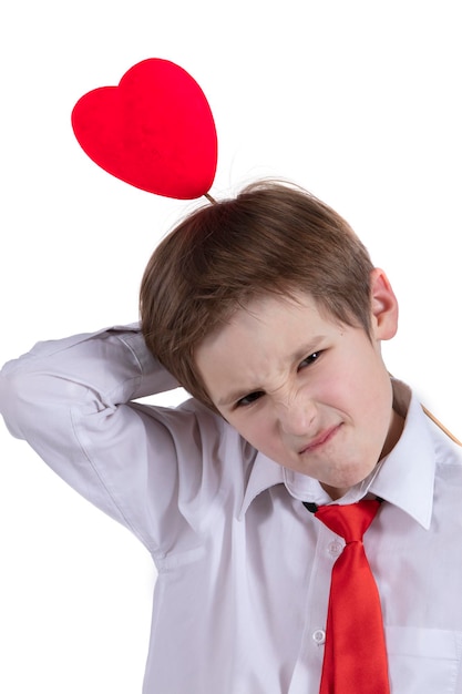 Enfant avec Valentine Un garçon avec un cœur rouge grimace