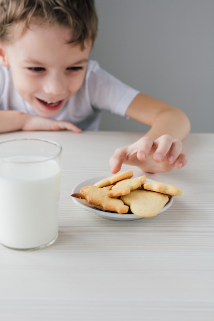 Un enfant vole sur une assiette de biscuits maison fraîchement cuits