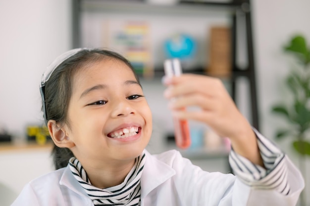 Enfante asiatique apprenant la chimie des sciences avec un tube à essai faisant des expériences à l'école laboratoire éducation des sciences chimie et concepts des enfants Développement précoce des enfants