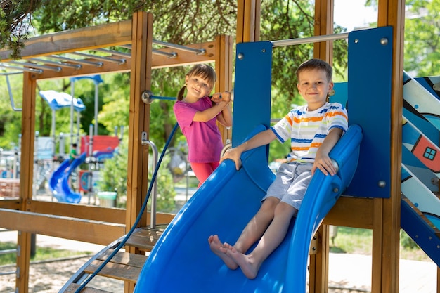 Des enfants actifs et joyeux jouent sur l'aire de jeux extérieure