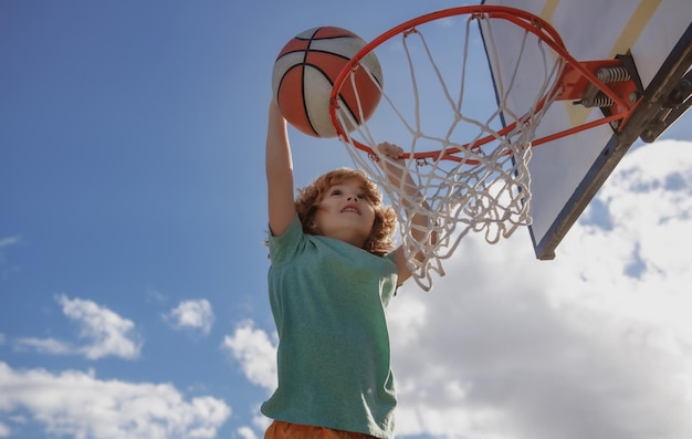 Enfants actifs profitant d'un jeu de plein air avec basket-ball en plein air sur une aire de jeux