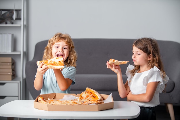 Enfants affamés mangeant de la pizza Enfants excités mangeant de la pizza