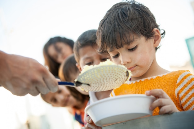 Enfants affamés nourris par des œuvres de charité