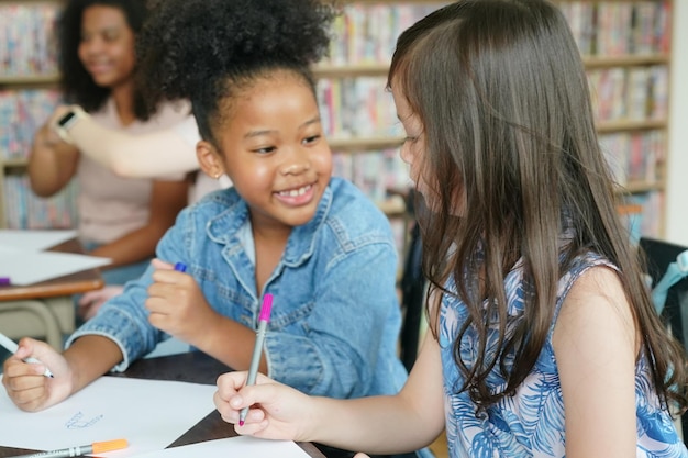 Enfants africains dessinant et faisant leurs devoirs en classe jeune fille heureuse étude drôle à l'école