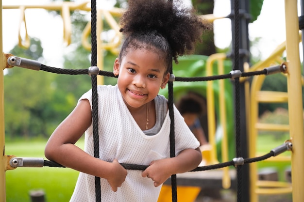 Enfants afro-américains fille jouant dans l'aire de jeux de la zone d'aventure au parc