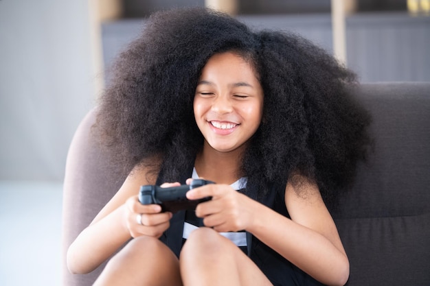 Les enfants afro-américains de fille jouent au jeu à la maison