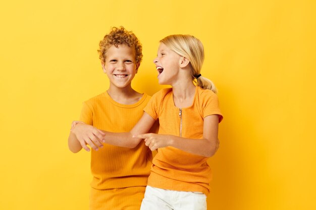 Enfants d'âge préscolaire mignons câlins mode enfance divertissement fond jaune inchangé