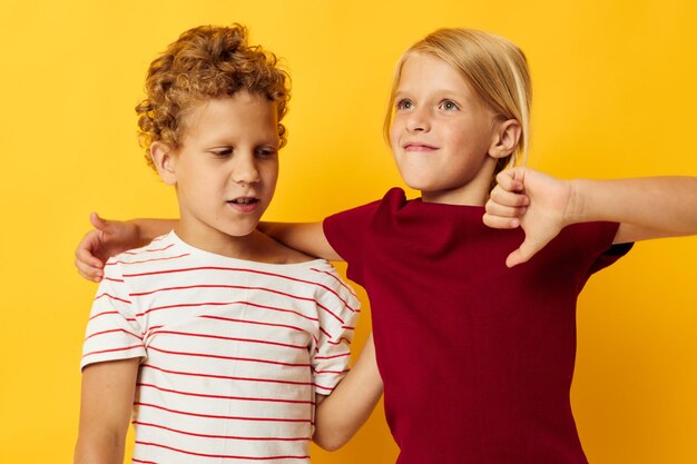 Enfants d'âge préscolaire mignons câlins mode enfance divertissement fond jaune