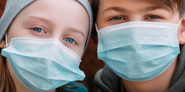 Enfants d'âge scolaire dans des masques médicaux. portrait d'écoliers.