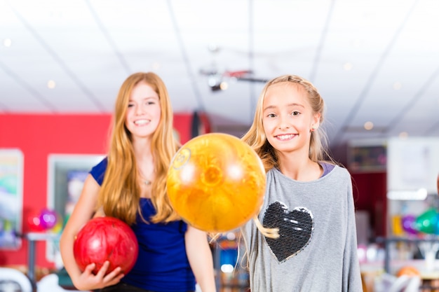 Enfants amis jouant ensemble au centre de bowling