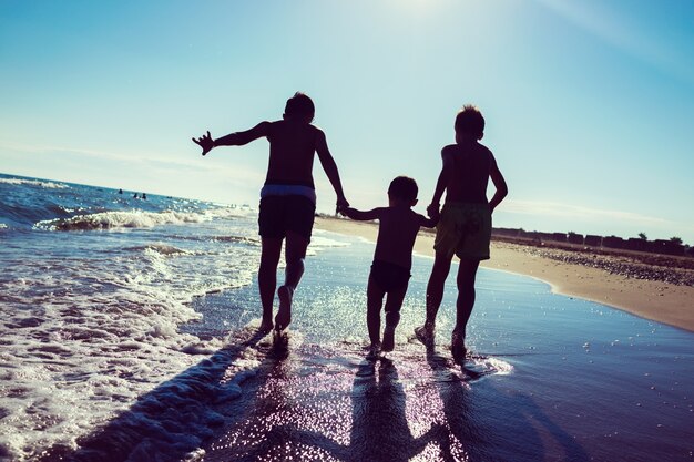 Enfants amusants jouant des éclaboussures à la plage