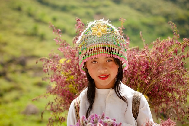 Photo enfants appartenant à une minorité ethnique non identifiés avec des paniers de fleurs de colza à hagiang, au vietnam. hagiang est une province la plus septentrionale du vietnam