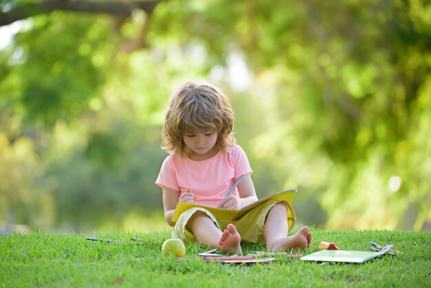 Enfants apprenant dans le parc. Élève mignon à l'école primaire.