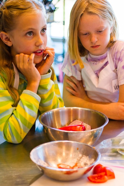 Photo les enfants apprennent à cuisiner dans un cours de cuisine.