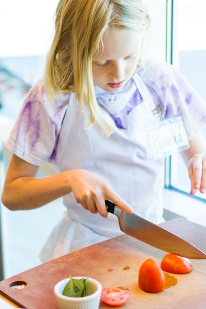 Les enfants apprennent à cuisiner dans un cours de cuisine.