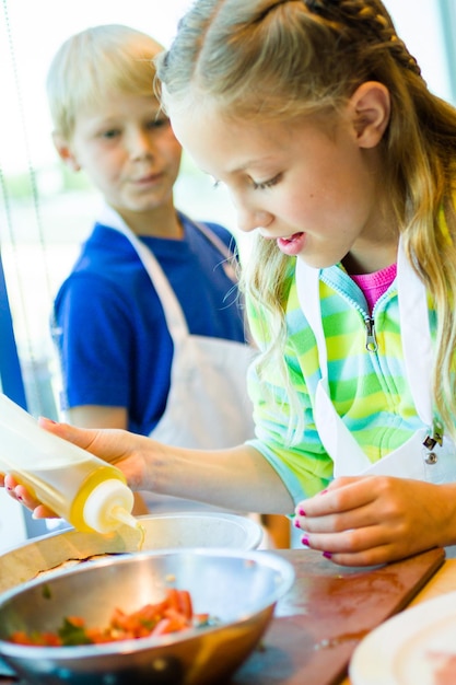 Les enfants apprennent à cuisiner dans un cours de cuisine.