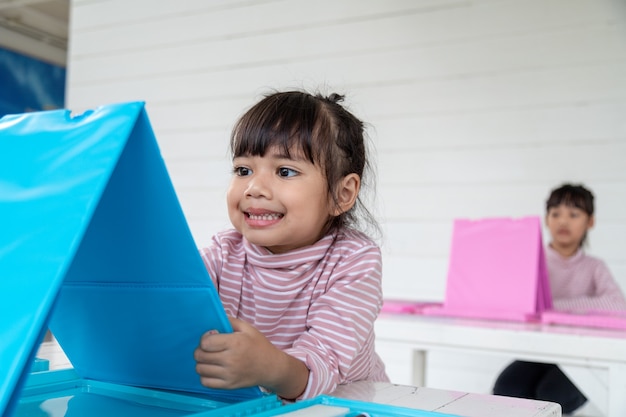 Les enfants asiatiques apprennent à dessiner en classe.