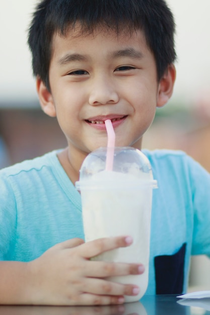 Enfants asiatiques buvant une boisson fraîche dans un ourson en plastique