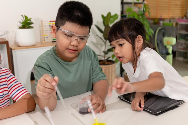 Des enfants asiatiques font des expériences chimiques chez eux