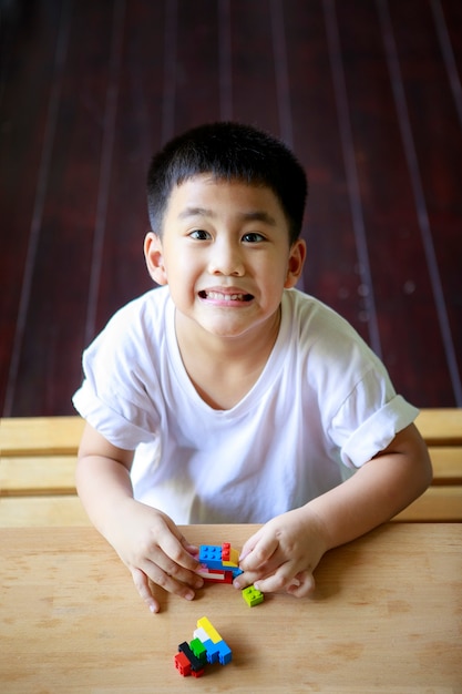 Enfants asiatiques jouant jouet enfant à la maison salon