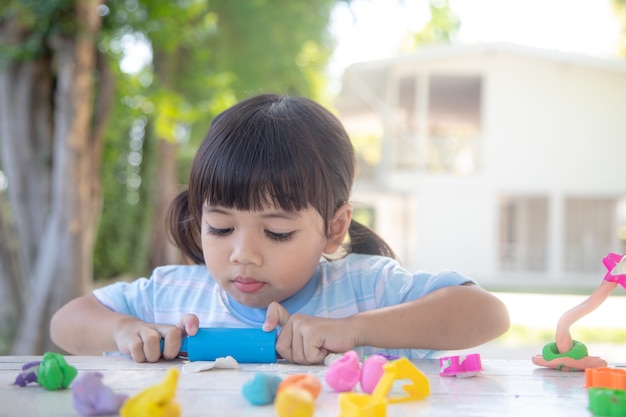 Les enfants asiatiques jouent avec des formes de moulage en argile, apprenant par le jeu