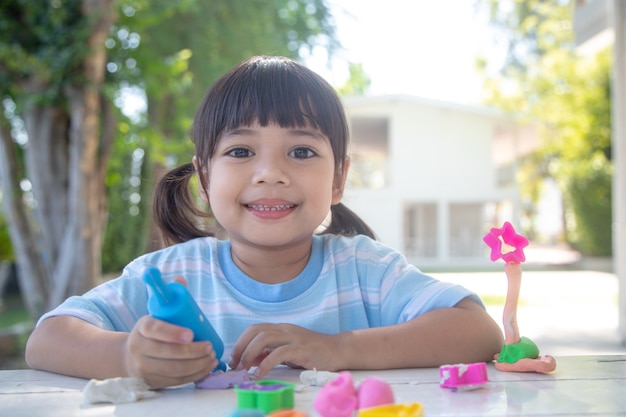 Les enfants asiatiques jouent avec des formes de moulage en argile, apprenant par le jeu