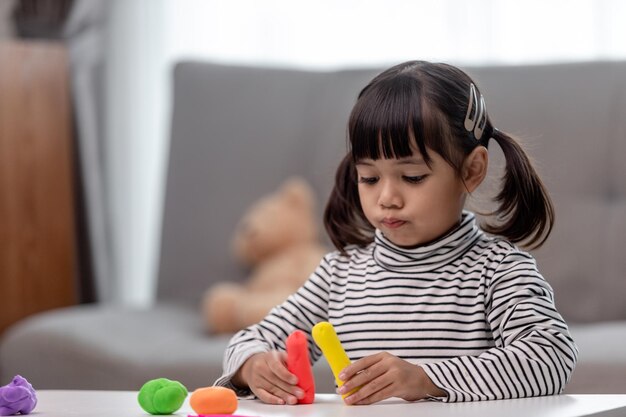 Les enfants asiatiques jouent avec des formes de moulage d'argile en apprenant par le jeu