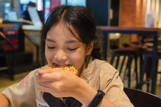 Les enfants asiatiques mangent une pizza