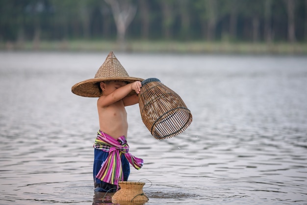 Enfants asiatiques pêchant dans la rivière