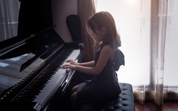 Les enfants asiatiques pratiquent le piano pour s'entraîner à améliorer leurs capacités musicales