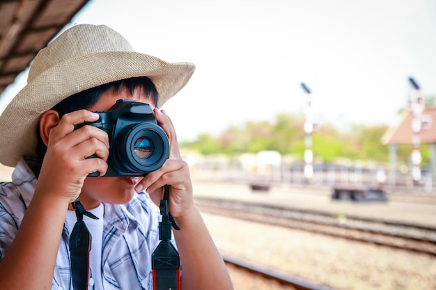 Les enfants asiatiques prennent des photos avec un reflex numérique. Voyage en train.